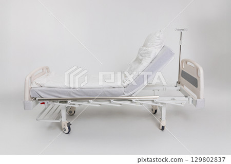 An Adjustable Hospital Bed featuring fresh White Linens to enhance Patient Comfort and care 129802837