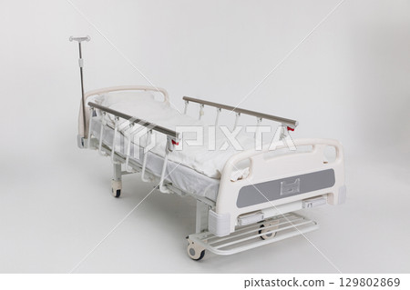 A hospital bed designed with multiple adjustable features alongside a convenient IV stand A hospital bed designed with multiple adjustable features alongside a convenient IV stand 129802869