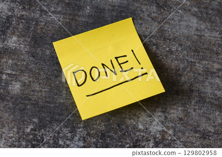 A yellow sticky note with the word done written in black ink  129802958