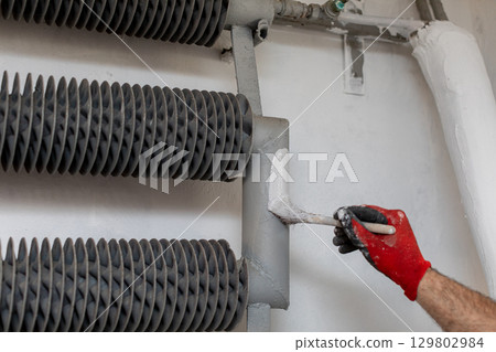 Hand painting metal pipes in industry demands skilled craftsmanship and attention to detail Hand painting metal pipes in industry demands skilled craftsmanship and attention to detail 129802984