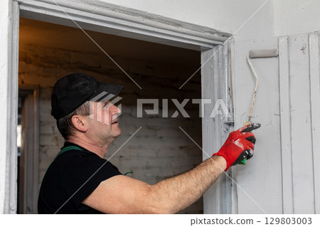 A skilled painter specializes in working on interior walls of homes and buildings A skilled painter specializes in working on interior walls of homes and buildings 129803003