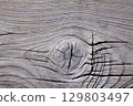 gray wooden texture background with knots and cracks, damaged by wind and sand 129803497