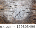 Wooden surface with knots and cracks, affected by wind and sand 129803499