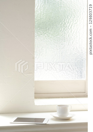 Tablet and coffee cup on the windowsill 129803719