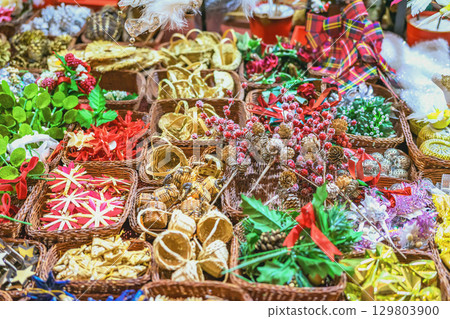 Handmade Christmas decorations closeup, top view. Assorted handmade Christmas decorations arranged in wicker baskets at festive market. Concept of holiday craft decor, colorful seasonal tradition Handmade Christmas decorations closeup, top view. Assorted handmade Christmas decorations arranged in wicker baskets at festive market. Concept of holiday craft decor, colorful seasonal tradition 129803900