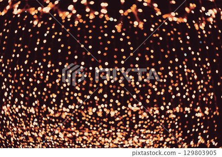 Lights bokeh background. Warm glowing lights create dreamy bokeh effect against dark festive background. Concept of holiday lights, cozy atmosphere, magical winter nights Lights bokeh background. Warm glowing lights create dreamy bokeh effect against dark festive background. Concept of holiday lights, cozy atmosphere, magical winter nights 129803905