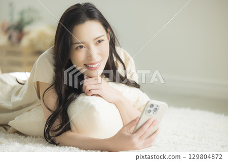 一個操作智能手機的年輕女子 129804872