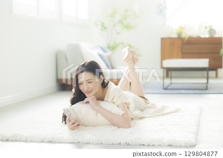 A young woman operating a smartphone A young woman operating a smartphone 129804877