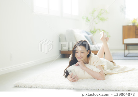 A young woman operating a smartphone 129804878