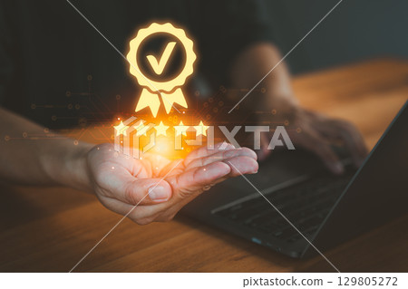 Person holding and showing the best quality assurance with golden five stars, representing high quality service, customer satisfaction, digital excellence, guarantee, standard, and testimonial. 129805272