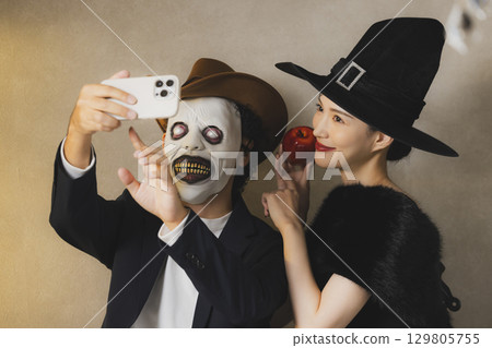 身著萬聖節服裝的男女 身著萬聖節服裝的男女 129805755