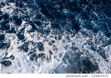Top down aerial view of sea water surface. White foam waves texture as natural background. Top down aerial view of sea water surface. White foam waves texture as natural background. 129805872