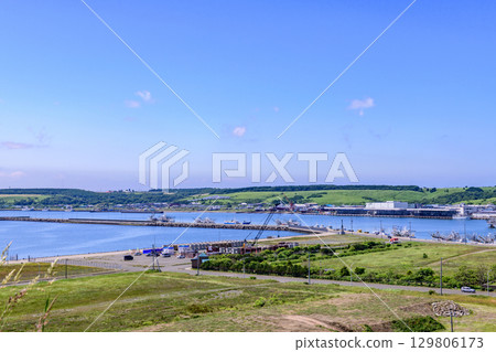 Coastline stretching from Cape Hanasaki to Ochiishi, town and fishing port, blue summer sky and seascape (Nemuro City, Hokkaido) 129806173