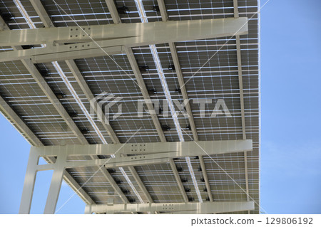 Solar panels installed over parking lot canopy shade for parked cars for effective generation of clean energy 129806192