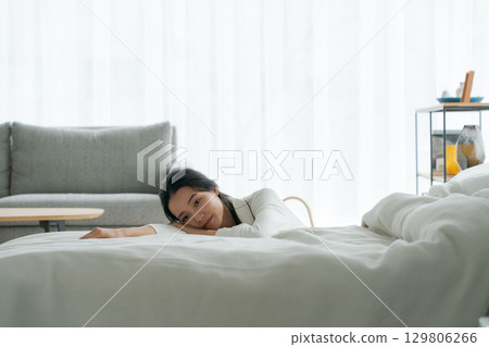A woman lying exhausted in bed 129806266