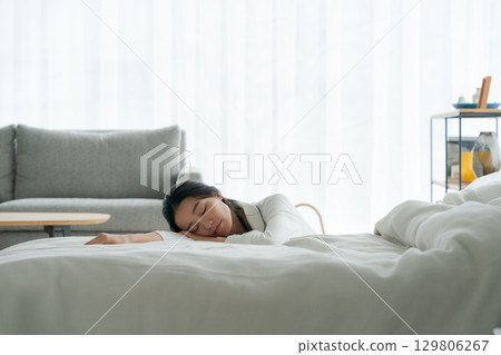 女人精疲力竭地躺在床上 女人精疲力竭地躺在床上 129806267