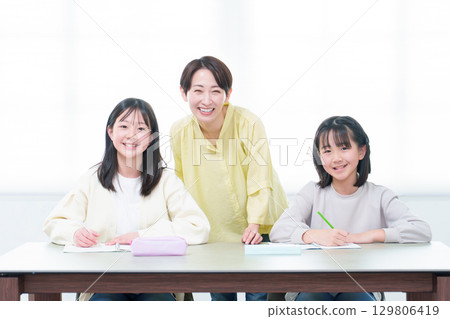 Girl studying, mother, teacher, tutor 129806419