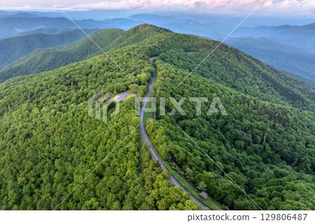Winding road at Mount Mitchell Overlook on Blue Ridge Parkway in North Carolina Appalachian mountains. Forest with green canopies in summertime. Driving through wild woods nature in summer 129806487