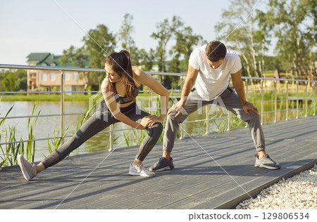 Couple family legs stretches outdoors, standing on path engaging in exercise, warming up  129806534