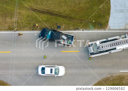 Car accident on highway road in Florida. Emergency services personnel helping victims of vehicle crash on city street in USA Car accident on highway road in Florida. Emergency services personnel helping victims of vehicle crash on city street in USA 129806582