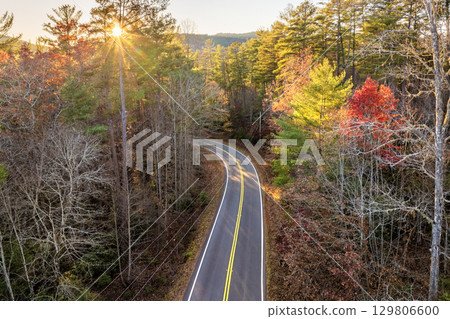Road trip in fall season through Appalachian forest in Tennessee. Car driving on a winding road under colorful autumn canopy 129806600