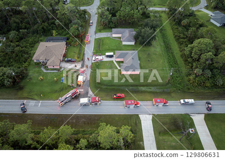 First responders arrived at fire alarm call ready to extinguish fire of burning house. Emergency service personnel responding to potential fire hazard at Florida home 129806631