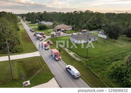 Firefighter trucks at fire alarm scene of suburban house. First responders at potential fire hazard at Florida home 129806632