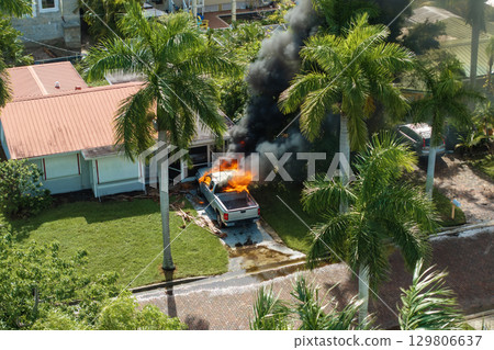 Firefighters extinguishing car fire on suburban street in Florida Firefighters extinguishing car fire on suburban street in Florida 129806637