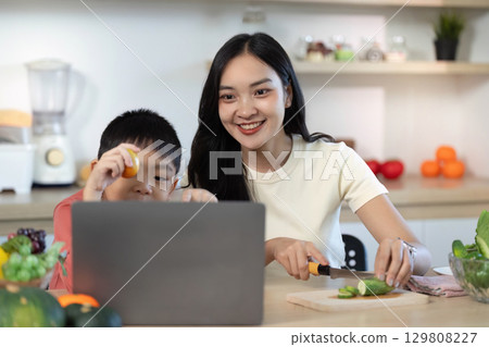 Joyful Cooking: Mother and Son Engaged in Healthy Meal Preparation Joyful Cooking: Mother and Son Engaged in Healthy Meal Preparation 129808227