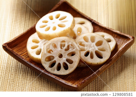 Cross section of lotus root cut into round slices with the skin still on 129808581