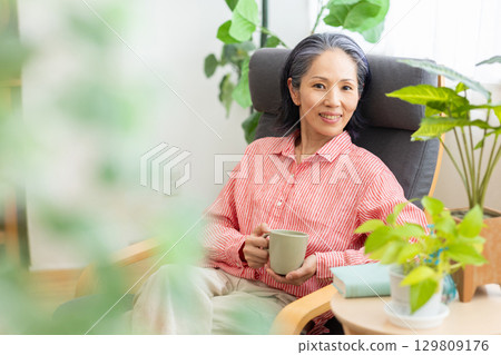 一個女人坐在沙發上和放鬆 129809176