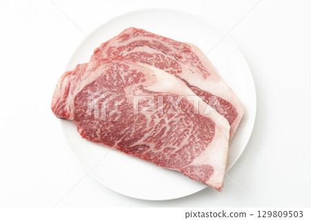 Steak meat on a white plate White background Steak meat on a white plate White background 129809503