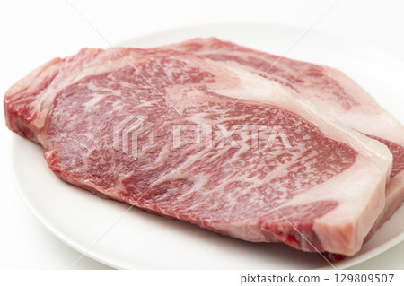 Steak meat on a white plate White background Steak meat on a white plate White background 129809507