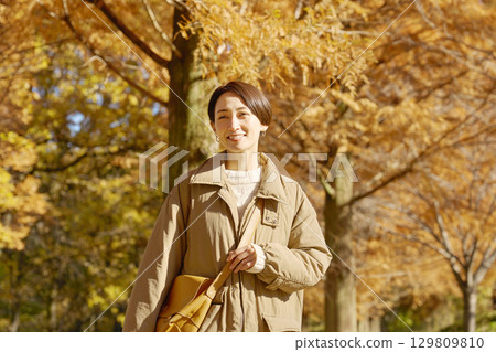 Middle-aged woman walking in the autumn park 129809810