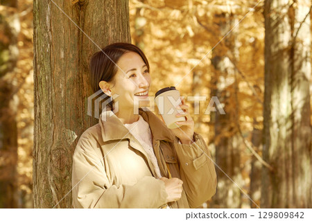 中年婦女在秋葉喝咖啡 129809842