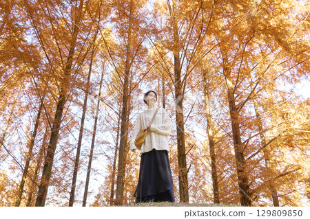 中年婦女在秋葉中行走 129809850