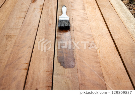 Paint brush and wood material in construction work. Paint brush and wood material in construction work. 129809887