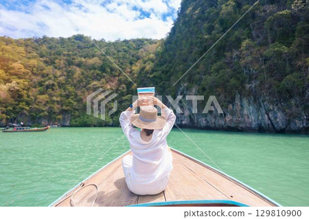 Happy Woman tourist in private longtail boat trip to koh Hong lagoon island at Krabi, Thailand. landmark, tropical destination, southeast Asia Travel, summer vacation, wanderlust and holiday concept Happy Woman tourist in private longtail boat trip to koh Hong lagoon island at Krabi, Thailand. landmark, tropical destination, southeast Asia Travel, summer vacation, wanderlust and holiday concept 129810900