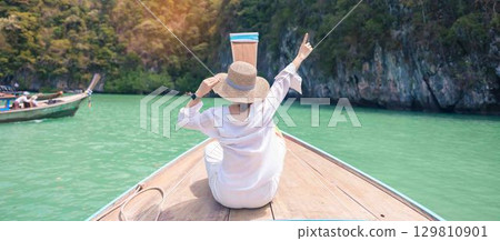 Happy Woman tourist in private longtail boat trip to koh Hong lagoon island at Krabi, Thailand. landmark, tropical destination, southeast Asia Travel, summer vacation, wanderlust and holiday concept Happy Woman tourist in private longtail boat trip to koh Hong lagoon island at Krabi, Thailand. landmark, tropical destination, southeast Asia Travel, summer vacation, wanderlust and holiday concept 129810901
