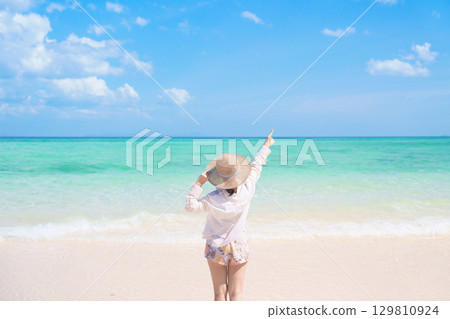 Happy Woman tourist with hat relaxing and enjoying on beach, young solo traveller looking beautiful sea view on tropical island. Southeast Asia destination, summer Travel, vacation and holiday Happy Woman tourist with hat relaxing and enjoying on beach, young solo traveller looking beautiful sea view on tropical island. Southeast Asia destination, summer Travel, vacation and holiday 129810924