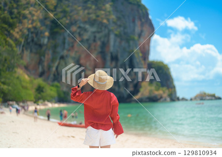 Woman tourist travel and sightseeing in Krabi, Thailand. happy traveller enjoy on beach at Phra nang Cave Beach near Railay Beach. summer trip, destination, Southeast Asia Travel and vacation concept 129810934