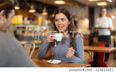 Couple, man and girl, meet in cafe for cup of coffee. Conversation of lovers 129811051