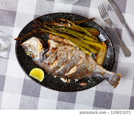 Dorada fish served with potatoes and asparagus 129811071