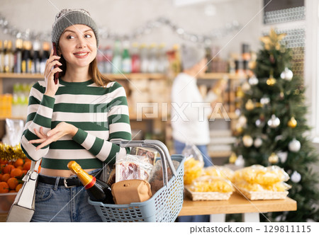 Woman talking on the phone in a Christmas shop Woman talking on the phone in a Christmas shop 129811115