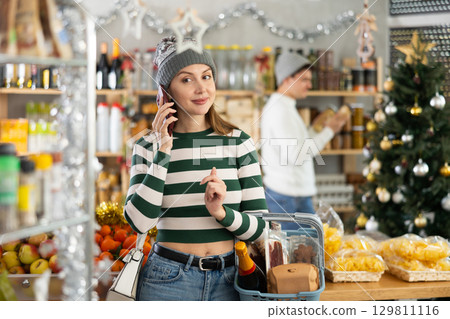 Woman talking on the phone in a Christmas shop 129811116
