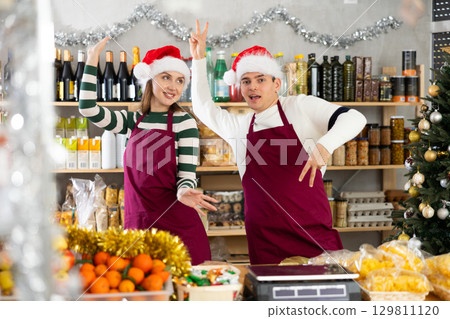 Woman and man sellers dance at counter in grocery store 129811120
