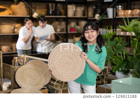 Young asian girl choosing wicker seat at home decor store 129811188