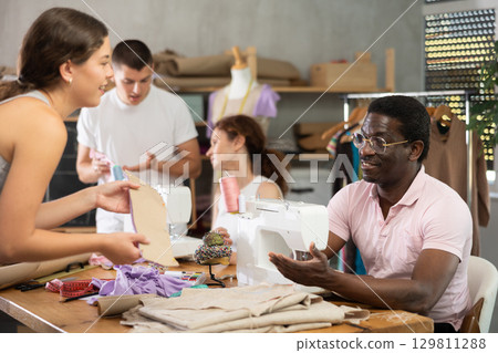 Man and woman sewing with machine and other works with textile Man and woman sewing with machine and other works with textile 129811288