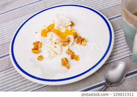 Portion of traditional Catalan dessert, mato with honey and nuts 129811311