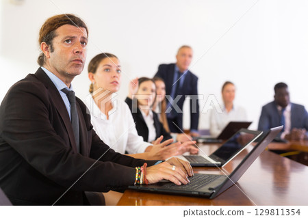 Businessman using laptop during conference in meeting room 129811354